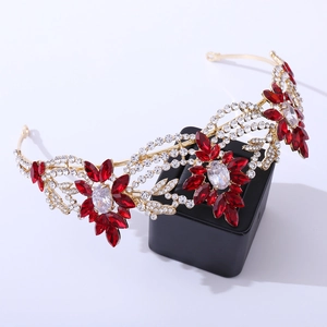 Detailed view of bridal crown with golden floral patterns, red gems and white crystals