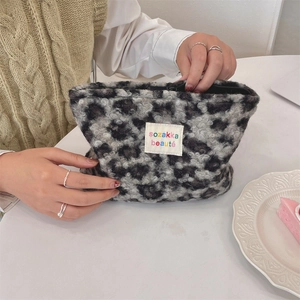 Detail of grey leopard plush makeup bag with soft texture and zipper closure