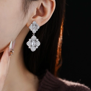 Gros plan de boucles d'oreilles fleurs en pavé de strass portées par un mannequin