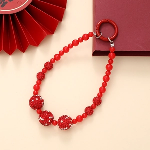 Close-up of red beaded charm with sparkling rhinestones and a metal spring ring clasp