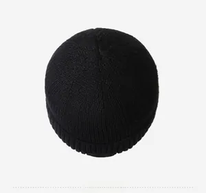 Top-down view of black knitted beanie with a folded hem and fine ribbed texture