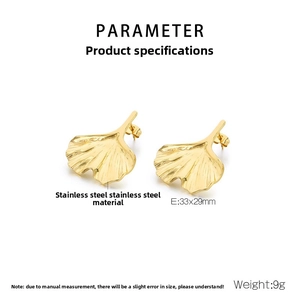 Macro detail of gold ginkgo leaf earrings showing brushed texture and 33x29mm dimensions