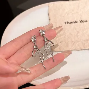 Detail of S925 silver drop earrings with star zircon, bowknot and long metal tassels