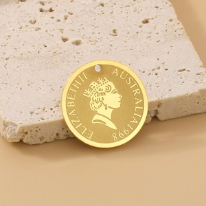 Detail of golden Elizabeth II coin pendant showing Queen profile on a textured stone base