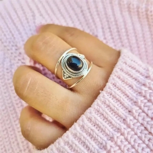Vintage silver ring with oval black onyx gemstone and bohemian rope design on knitwear