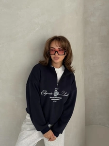 Detail of navy quarter-zip sweatshirt featuring white vintage British heritage printing