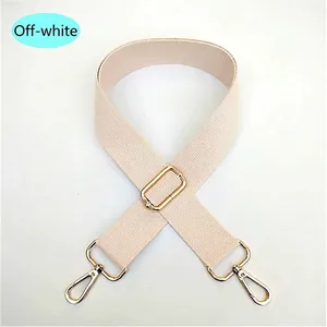 Close-up of adjustable beige canvas bag strap with durable gold metal swivel hooks