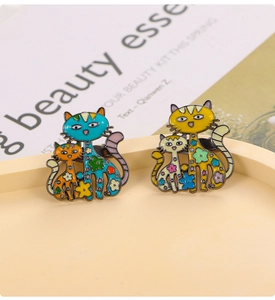 Détail de broches en émail chat avec motifs floraux sur un plateau en céramique