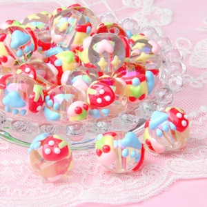 Detailed view of clear acrylic beads with colorful mushroom and heart patterns
