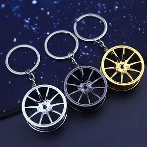 Detailed close-up of three metallic car wheel hub keychains in silver, gold, and grey colors