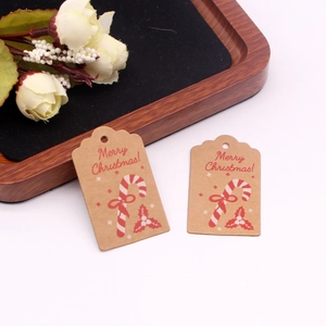 Close-up of brown kraft paper Christmas gift tags with red Merry Christmas print and holly