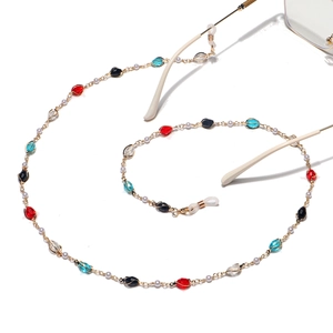 Handmade gold eyewear chain featuring colorful crystal beads and pearls on white background