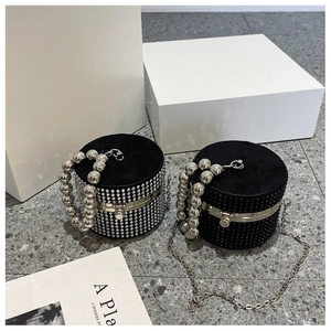 Detail showing two rhinestone cylinder evening bags with pearl-bead handles and chain straps