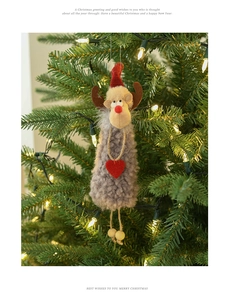 Plush reindeer Christmas ornament hanging on tree with warm lights and grey felt details