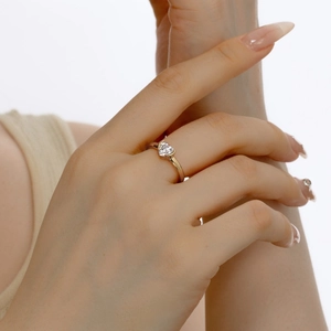 Macro detail of a 925 silver heart shaped zircon ring worn on a finger