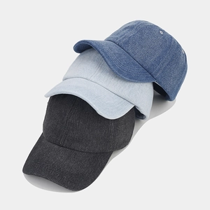 Detailed view of three washed denim baseball caps in dark grey, light blue, and mid-blue colors