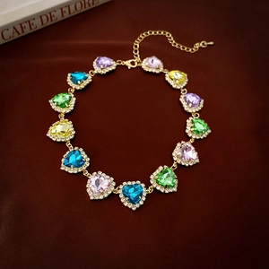 Choker dorato di lusso con cristalli colorati a cuore e bordi incastonati di diamanti fini
