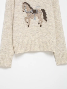 Close-up of fluffy oatmeal wool-blend knit sweater with detailed horse jacquard pattern