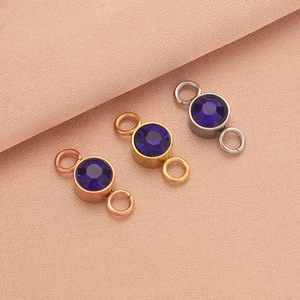 Detailed close-up of blue birthstone charms in rose gold, gold, and silver finishes