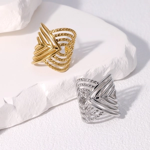 Vintage style gold and silver stainless steel layered rings on a white stone base