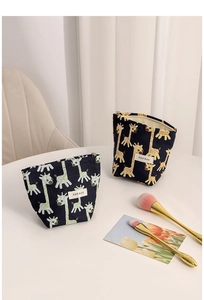 Detailed view of canvas giraffe jacquard makeup bags with secure zipper and side brand labels