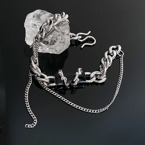 Titanium steel chain bracelet with black stone and hanging chain on a dark stone