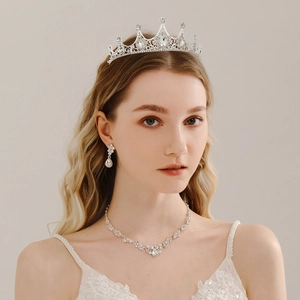 Close-up of bridal jewelry set with silver tiara, necklace and earrings on a model