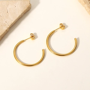 18K gold-plated stainless steel C-shaped hoop earrings on a minimalist stone background