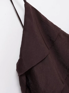 Détail macro d'une robe marron foncé avec fines bretelles et col à bordure brute