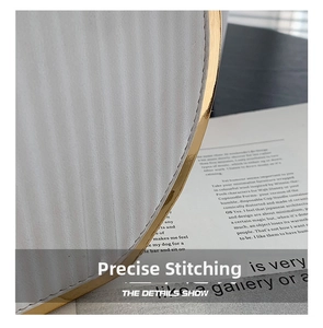 Detail showing precise stitching and gold metal edge on white wavy striped bag