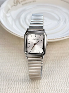 Silver square dial vintage watch with metallic elastic strap on neutral fabric