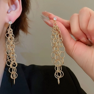 Gros plan de boucles d'oreilles feuille dorée avec perles et chaîne sur l'oreille
