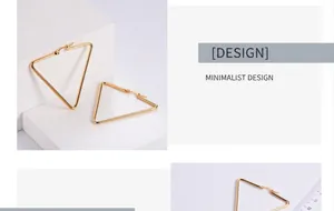 Detalle macro de pendientes triangulares dorados grandes con escala de medida y diseño