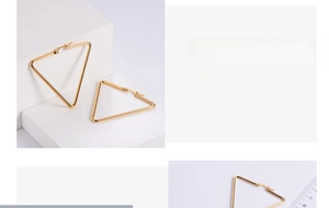 Macro detail of large gold triangle hoop earrings with size scale and minimalist design