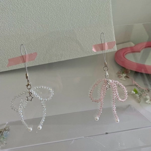 Detail of handmade crystal bow phone charms with pink beads and star pendants