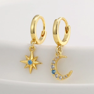 Elegant asymmetrical gold earrings with star and moon charms and blue cubic zirconia