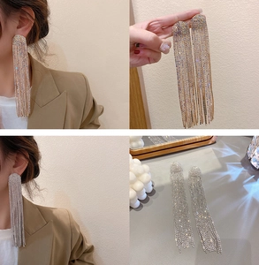 Macro detail of elegant long tassel earrings with sparkling rhinestones in gold and silver
