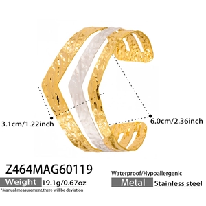 Makroaufnahme der welligen Hammerschlag-Textur und Gold-Silber-Optik des offenen Armreifs