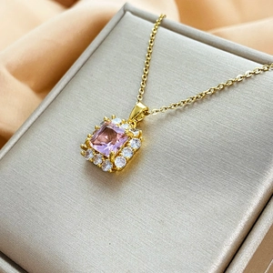 Dettaglio del ciondolo con zircone rosa quadrato su catena d'oro con castone a halo