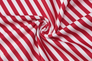 Detailaufnahme von weichem rot-weiß gestreiftem Strickstoff mit Spiralstruktur