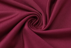 Macro shot of dark red knit fabric texture and elegant pleated details on the dress