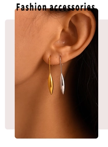 Macro detail of teardrop earrings with polished 18K gold and silver finish on model