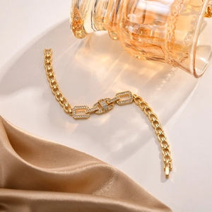 Detail of gold leaf and infinity heart bracelet with cubic zirconia on silk cloth