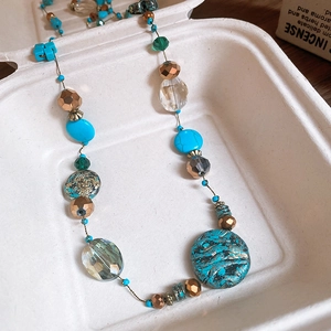 Detail showing bohemian layered beads necklace with turquoise stones and bronze metal spacers