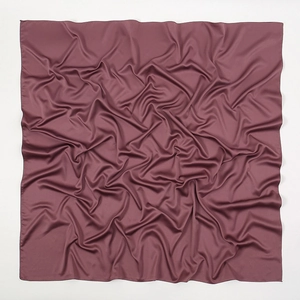 Detail of soft matte satin scarf in dark red featuring premium hemmed edges and silky texture