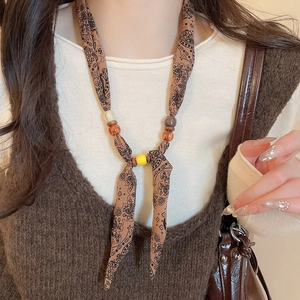 Detail of bohemian paisley print fabric necklace with decorative multicolor resin beads