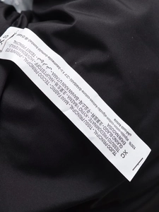 Detailed view of clothing care label showing 100 percent cotton fabric and size XS text