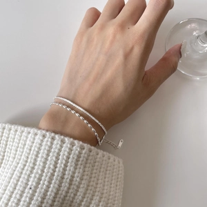 Close-up of layered S925 sterling silver cauliflower chain bracelets on model's wrist