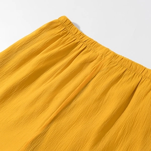 Detail of yellow elastic waistband and textured crinkle fabric on summer shorts