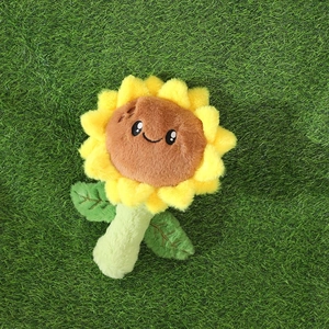 Peluche de tournesol souriante avec pétales jaunes sur fond d'herbe verte